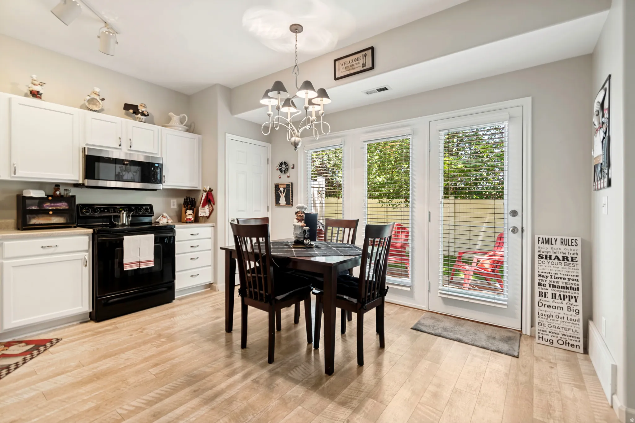 Eat-in kitchen featuring wood-finish flooring and white cabinetry