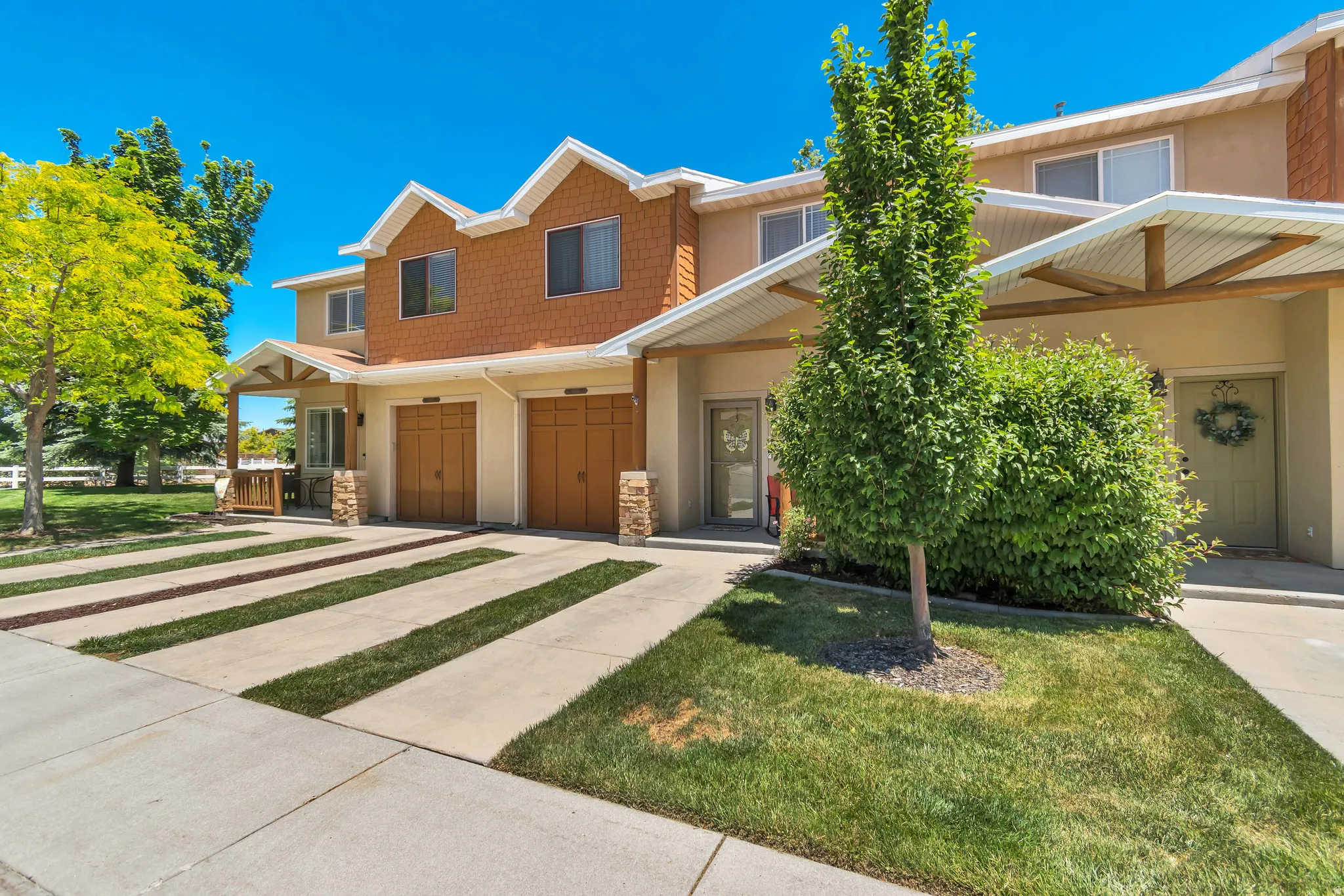 Townhome exterior featuring earth-toned stucco siding and cedar shake accents