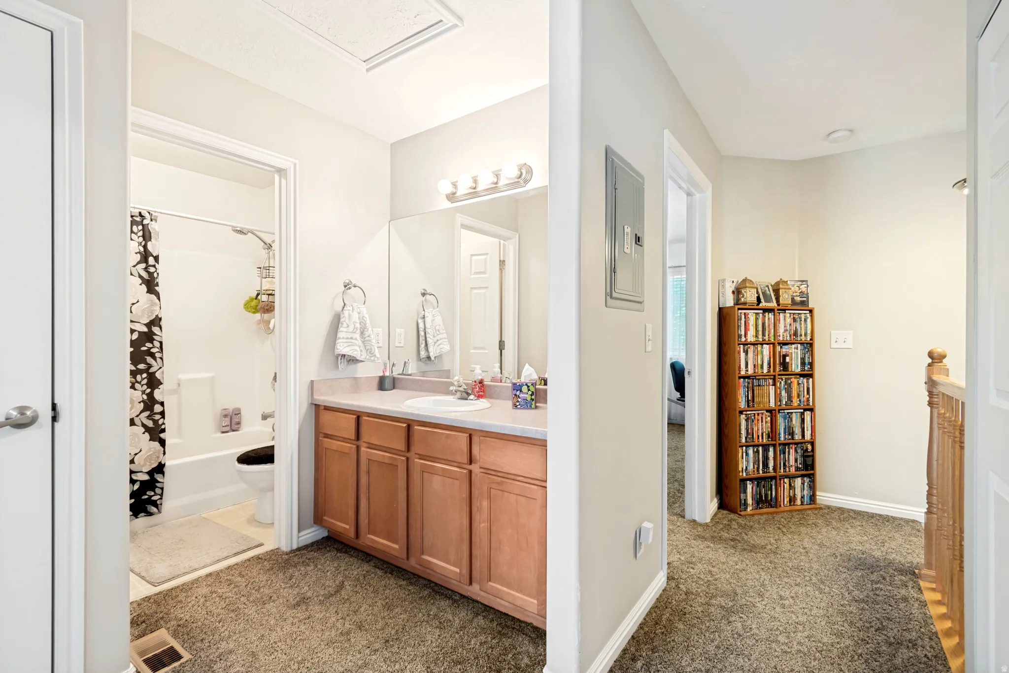 Bathroom featuring a single vanity with wood-finish cabinetry and a framed mirror