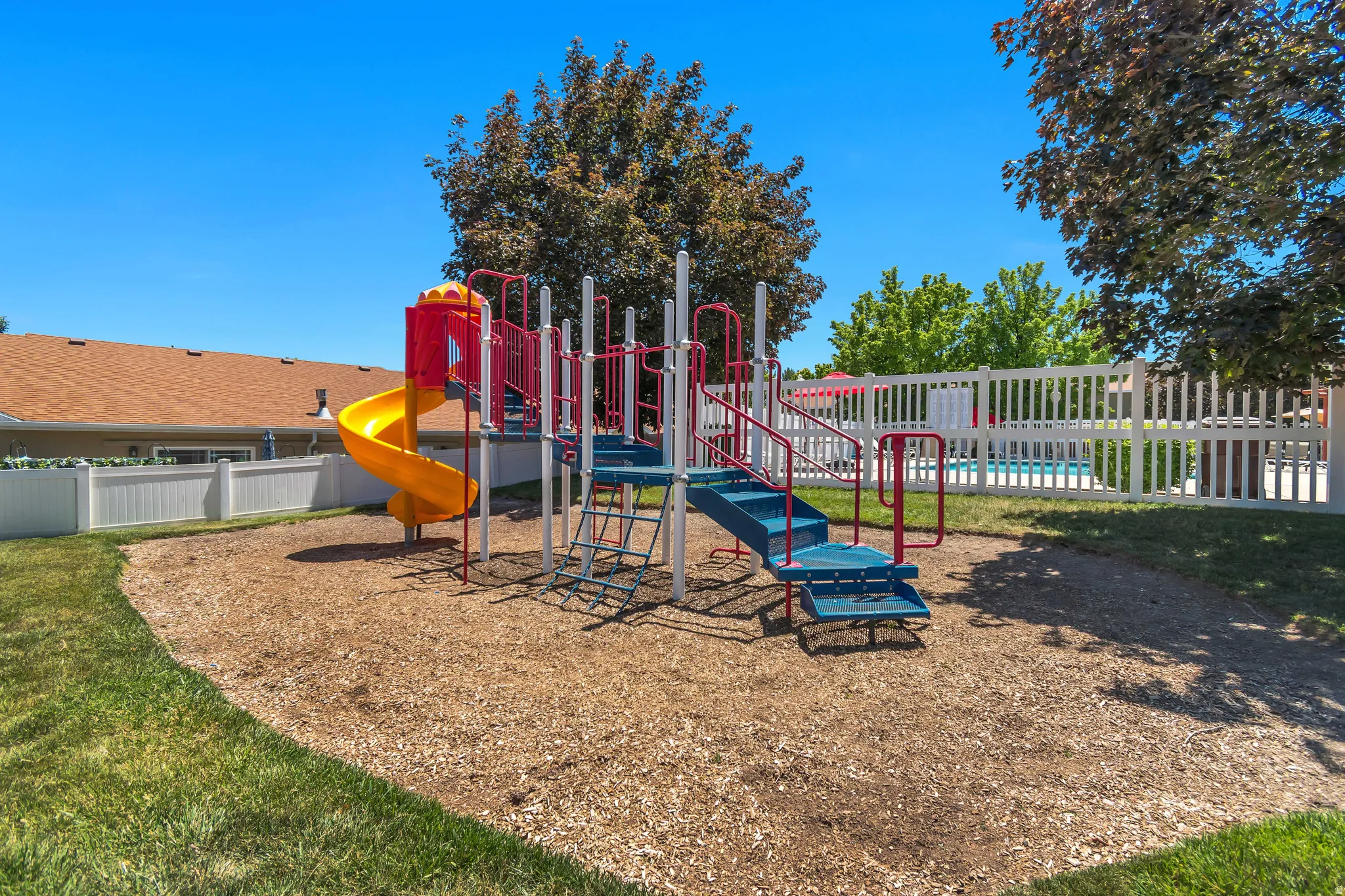 Outdoor playground with a multi-level structure, spiral slide, and climbing elements