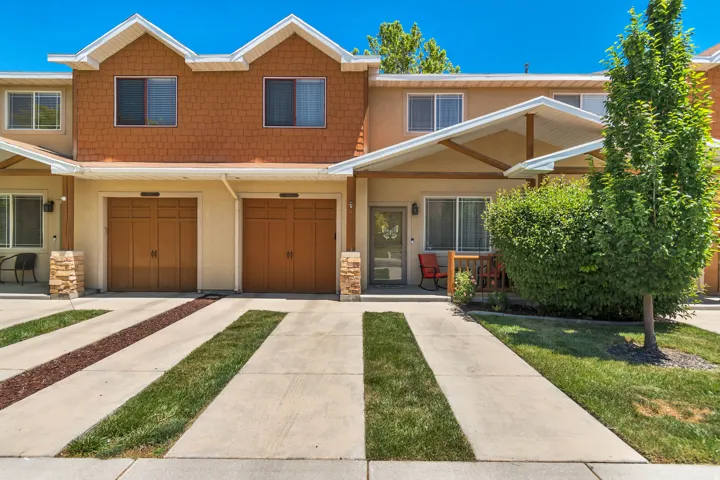 Multi-level townhome exterior featuring an attached two-car garage with wood-finish doors