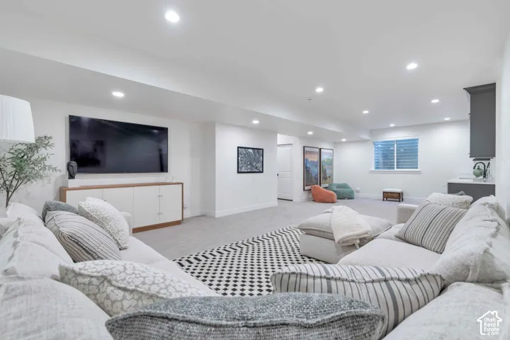 Open-concept interior featuring recessed lighting, wall-to-wall carpeting, and a built-in wet bar with dark cabinetry