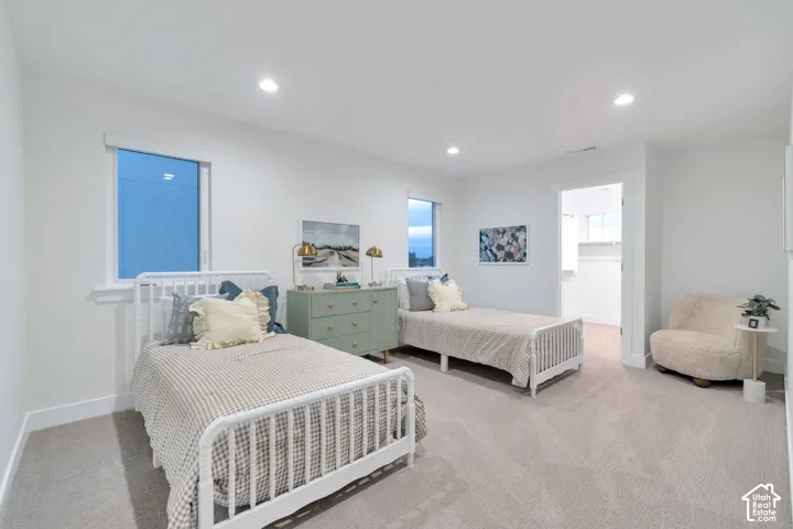 Neutral-toned carpeted flooring, recessed lighting, dual windows, and an interior reach-in closet