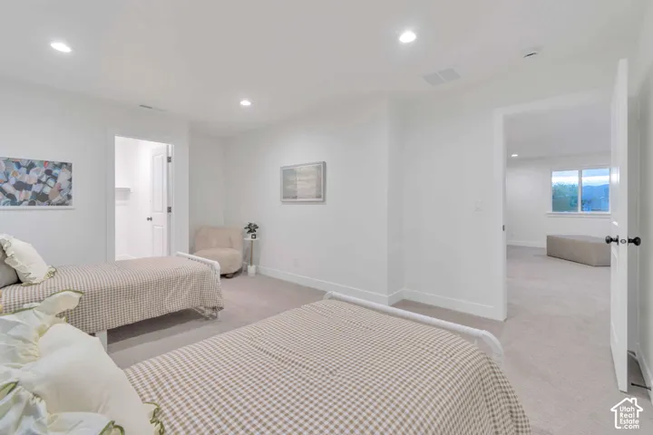 Neutral-toned carpeting, recessed ceiling lighting, and solid-core interior doors