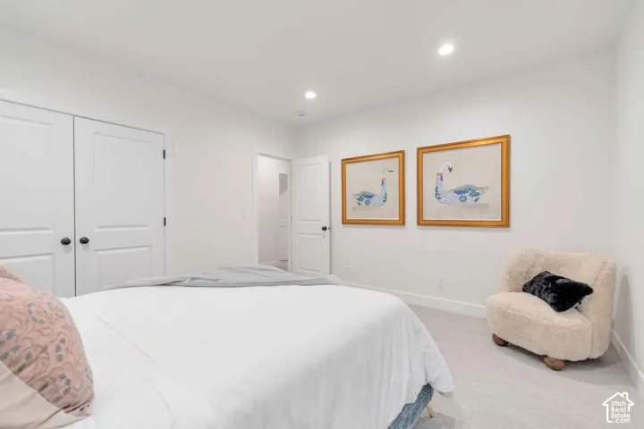 Neutral-toned carpeting, recessed ceiling lighting, two-panel interior doors, and solid-core closet doors with matte black hardware