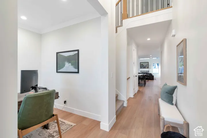 Entryway featuring wood-finish flooring, recessed lighting, and a staircase with metal balusters and a wooden handrail