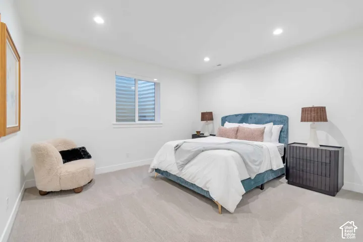 Neutral interior featuring wall-to-wall carpeting, recessed ceiling lighting, and an egress window
