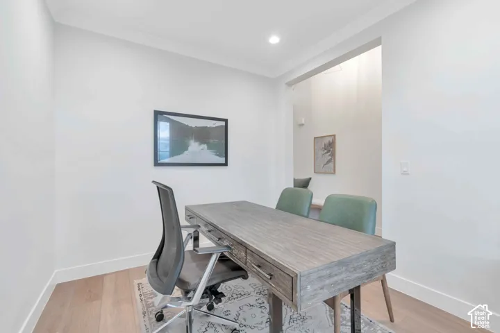 Neutral-toned room featuring wood-finish flooring, recessed lighting, and a wide cased opening