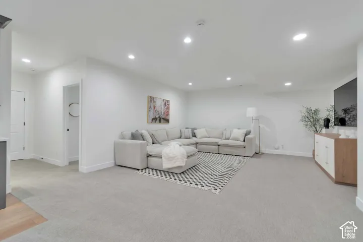 Neutral-toned carpeted flooring and recessed ceiling lighting