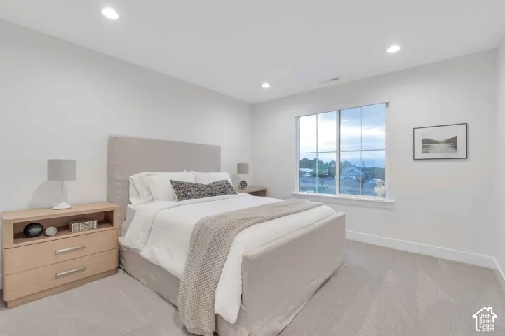 Neutral-toned interior space featuring recessed ceiling lighting, wall-to-wall carpeting, and a large multi-pane window