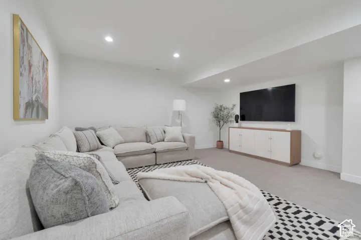 Neutral-toned interior space featuring recessed ceiling lighting, wall-to-wall carpeting, and a soffit ceiling detail