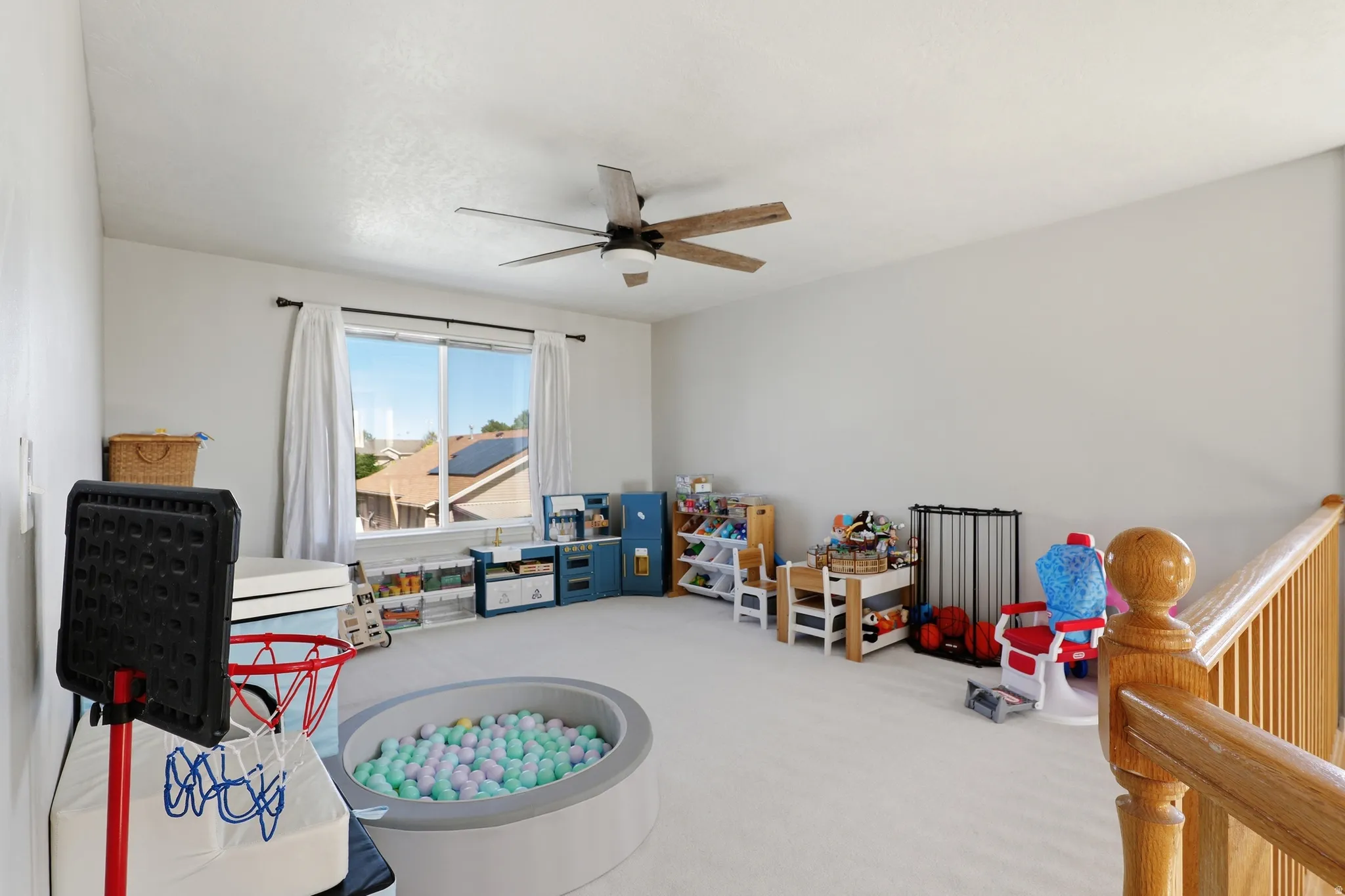 Spacious bonus room featuring light-colored carpeting and a ceiling fan with integrated lighting