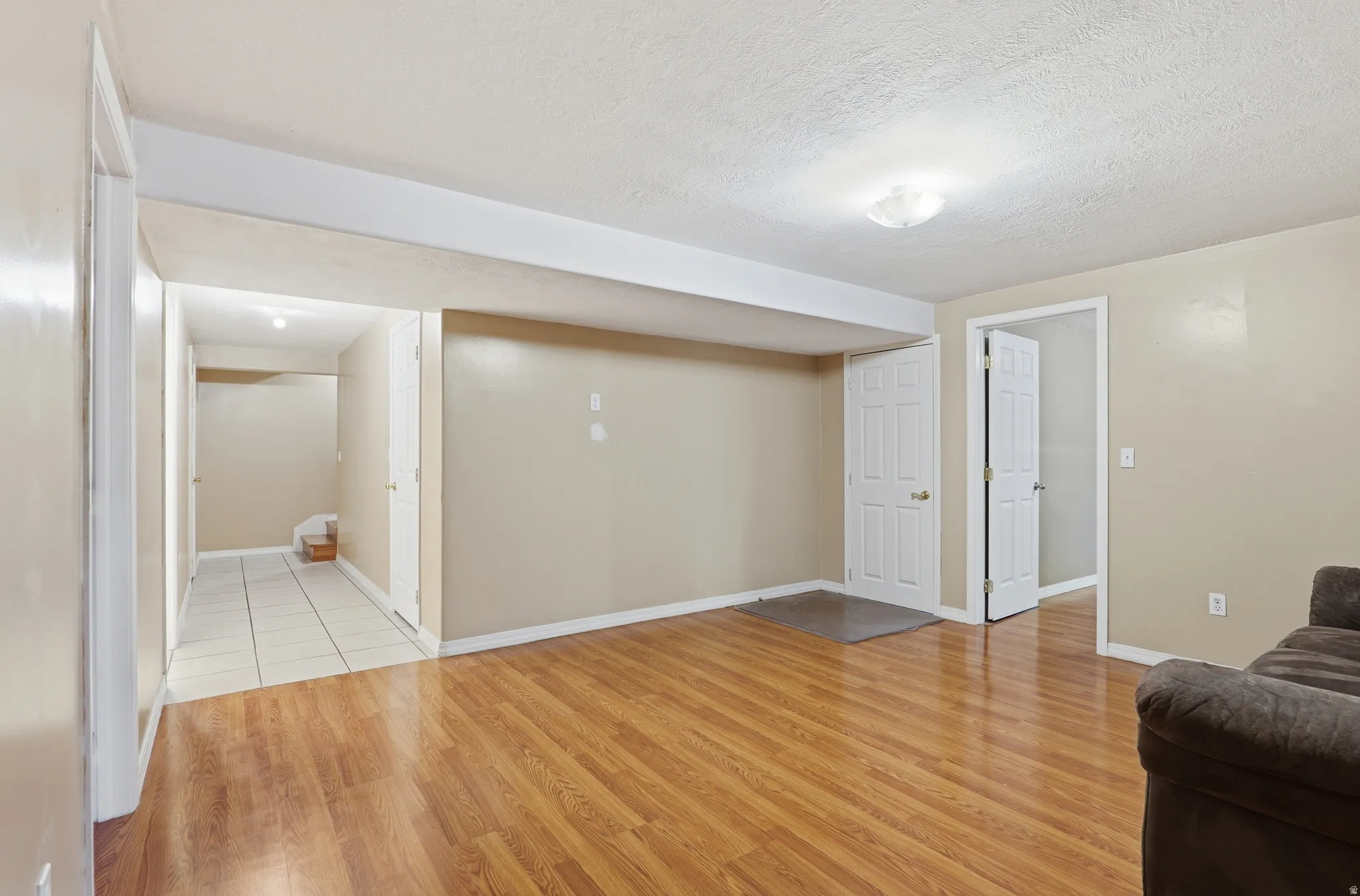 Spacious room featuring wood-finish flooring, neutral-toned walls, and recessed ceiling lighting