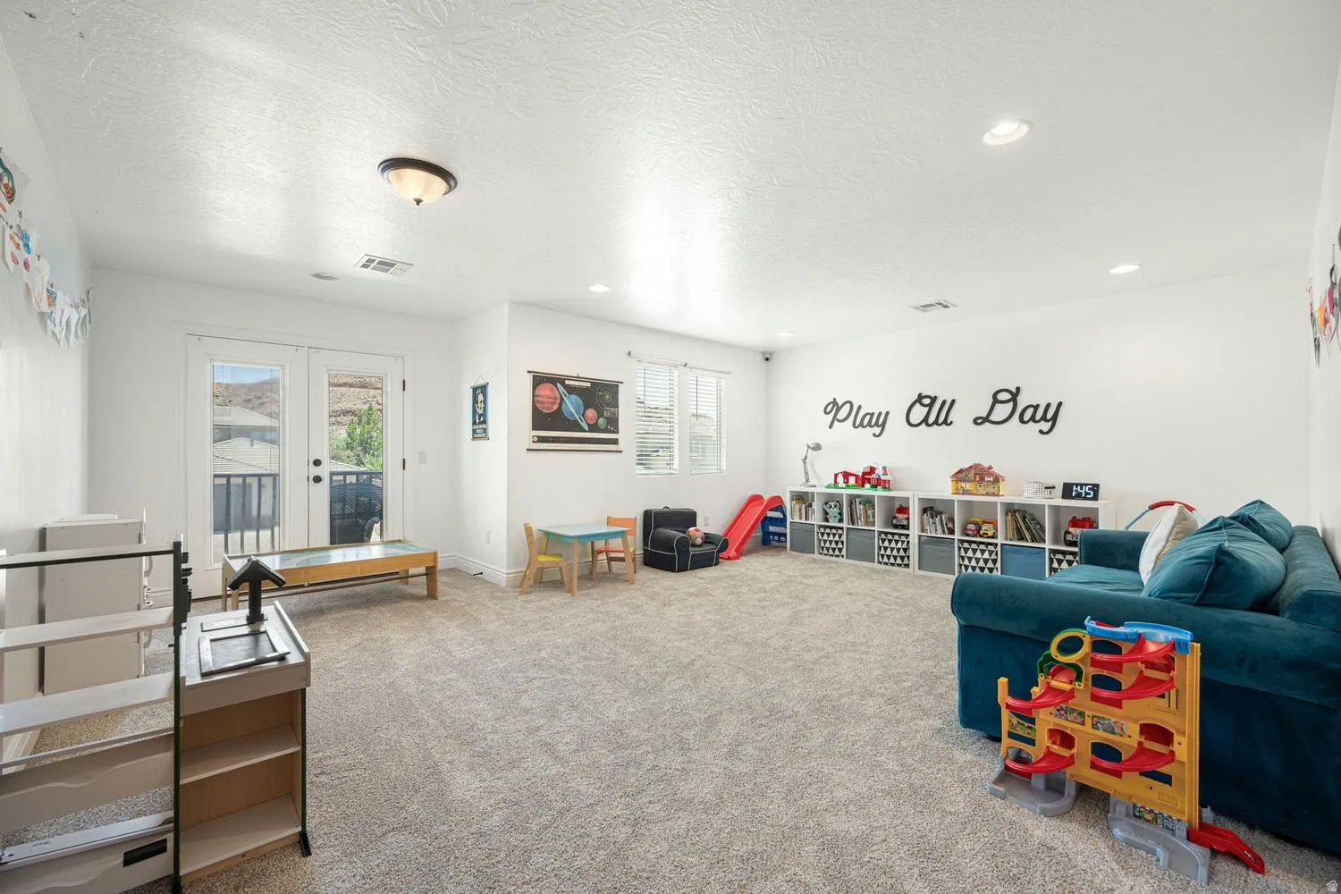 Spacious room featuring light-colored carpet flooring, white walls, and recessed lighting