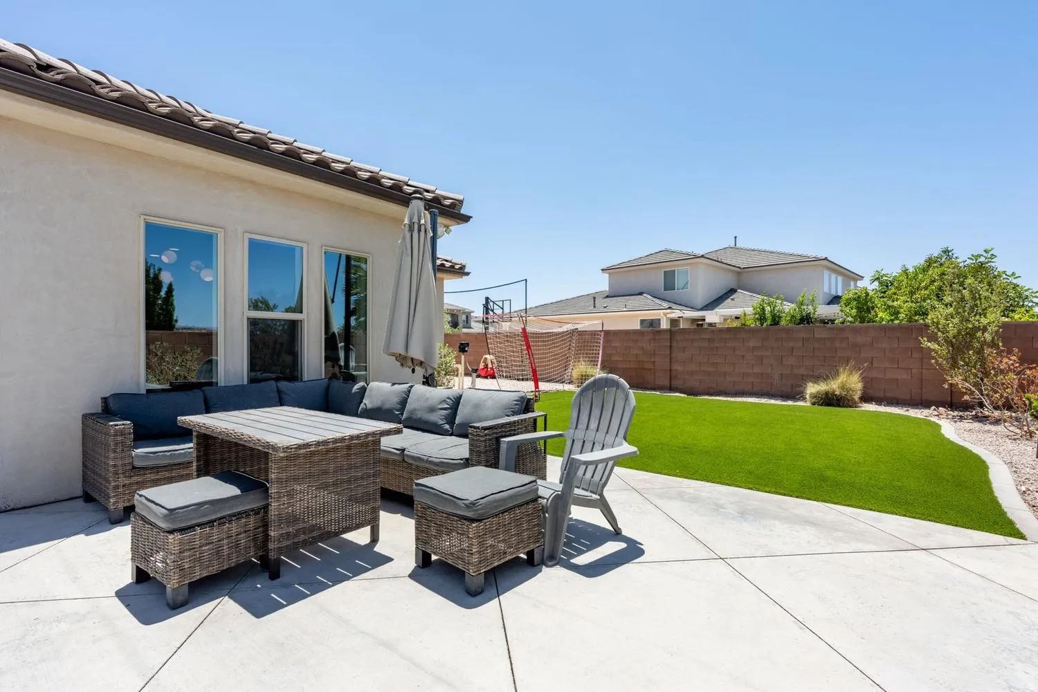 Expansive concrete patio with a stucco exterior and tiled roofline