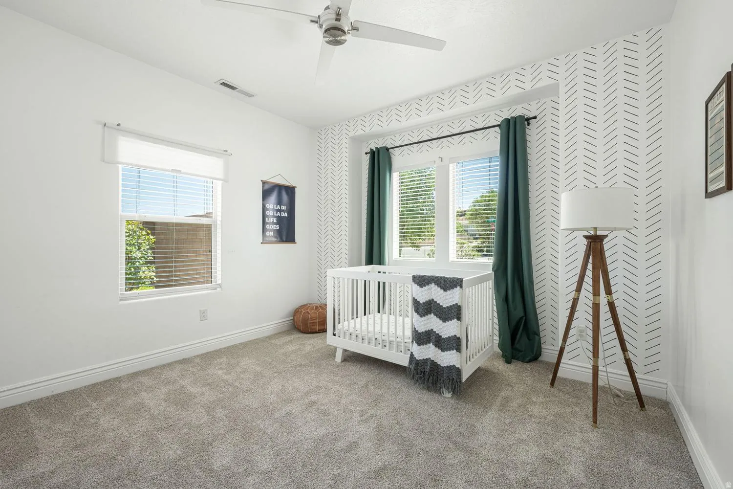 Carpeted room with a ceiling fan, a window with blinds, and white baseboards