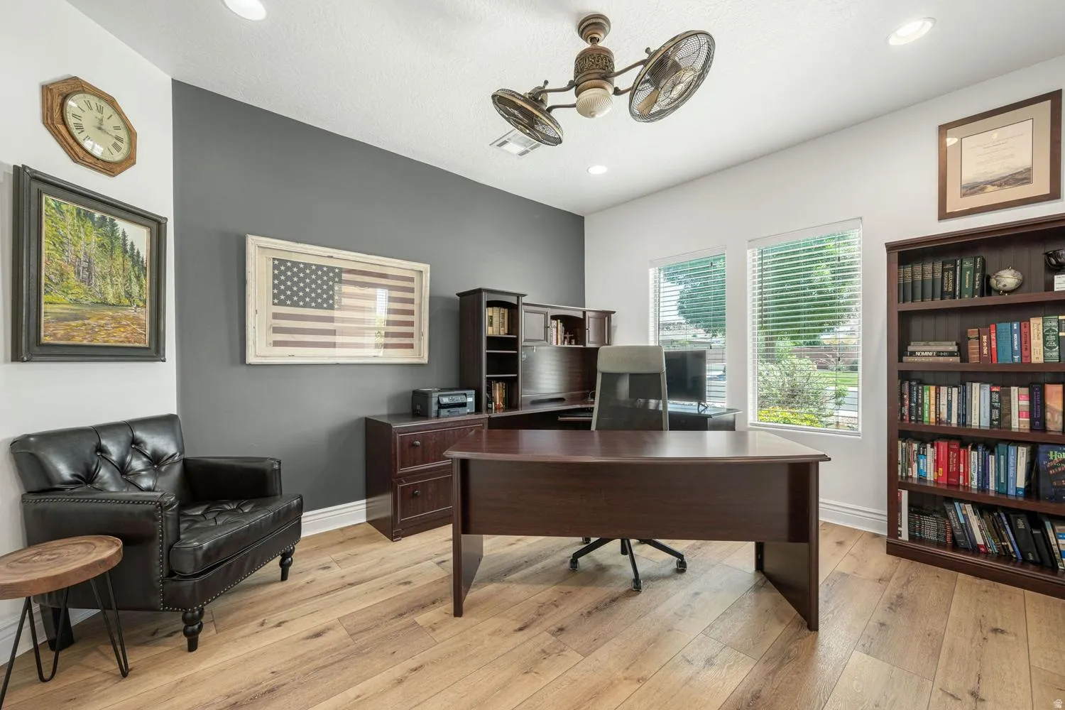 Dedicated room with wood-finish flooring, two large windows, recessed lighting, and a ceiling fan