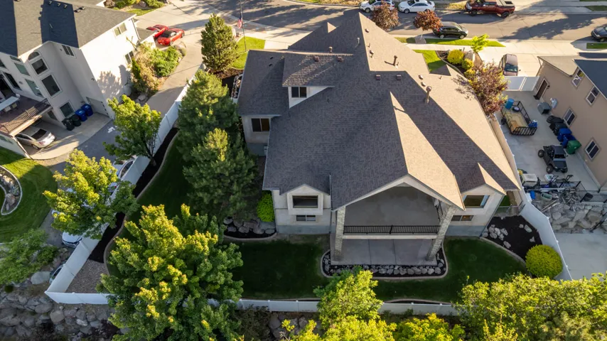 Backyard featuring a covered patio, manicured lawn, and mature trees