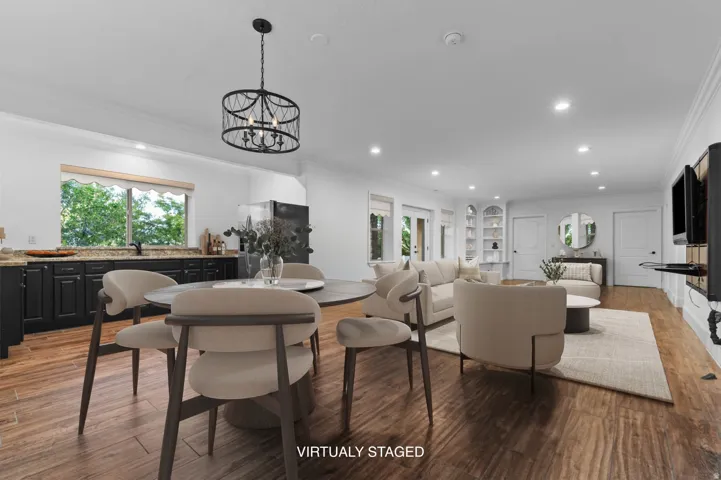 *Virtually Staged Image*  Open-concept living space featuring wood-finish flooring and recessed lighting