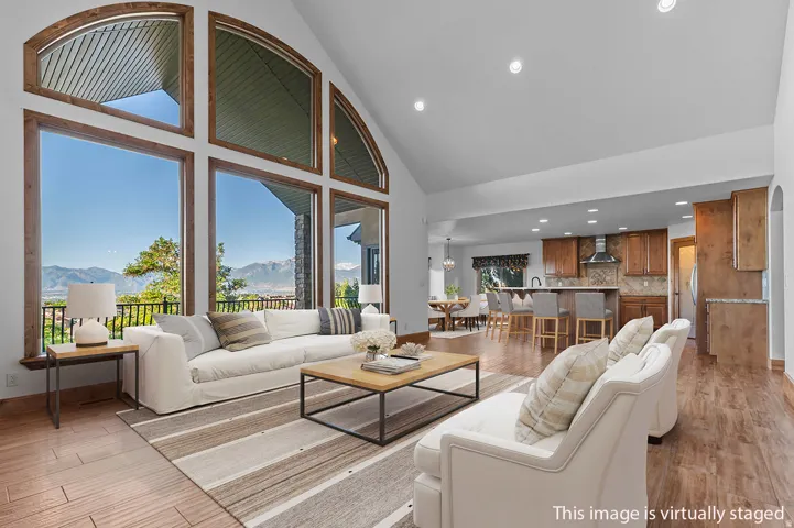 *Virtually Staged Image*  Vaulted living room with expansive arched windows and wood-finish flooring