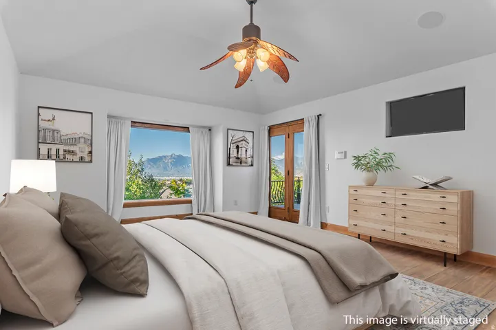 *Virtually Staged Image* Room featuring a vaulted ceiling with a decorative ceiling fan, wood-finish flooring, and white painted walls
