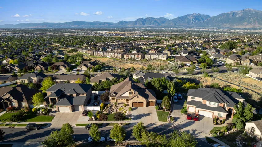 Suburban residential area with established homes and mature landscaping, framed by mountains