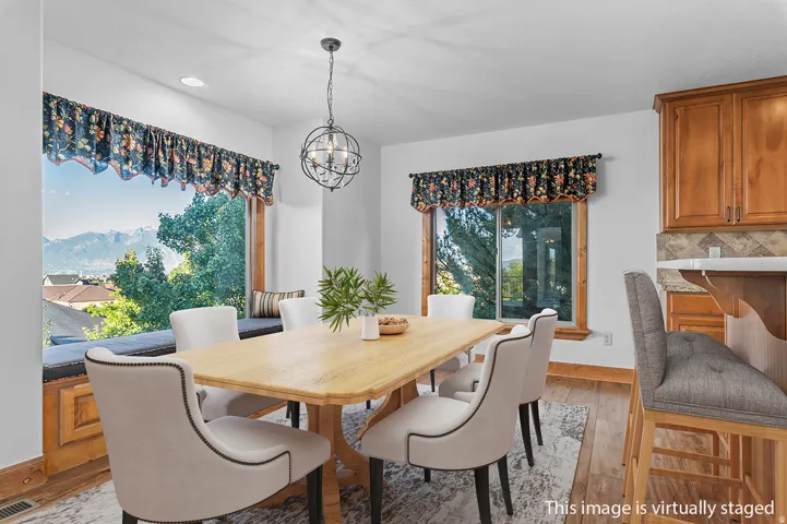 *Virtually Staged Image*  Dining area featuring a bay window with a built-in bench, wood-finish flooring, and a contemporary spherical chandelier