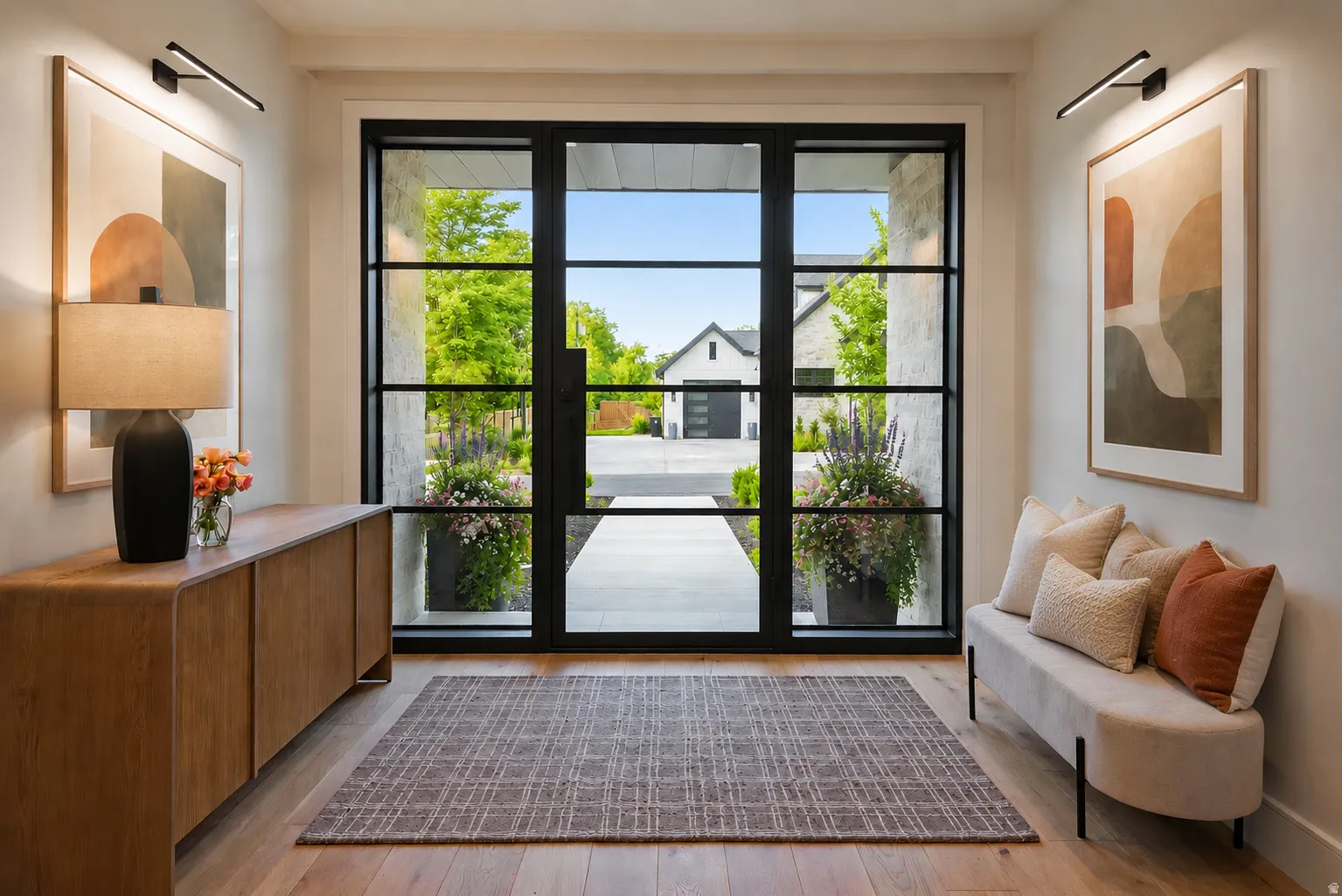 Grand entryway featuring a black-framed glass entry door, wood-finish flooring, and white walls