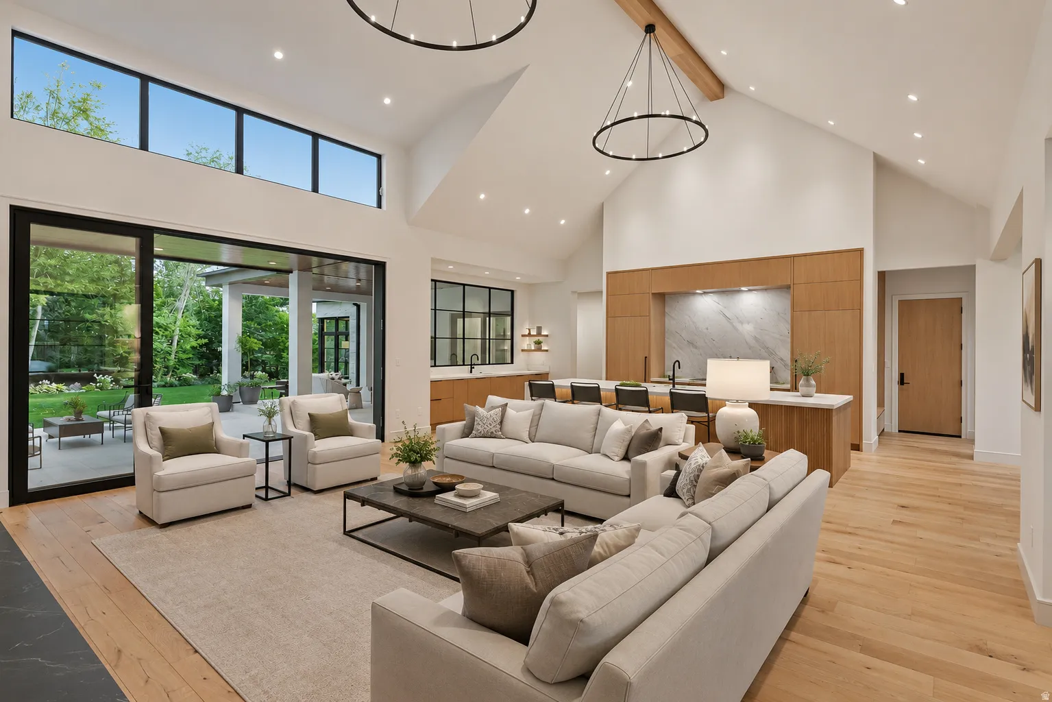 Vaulted great room with wood-finish flooring and a wood beam accent