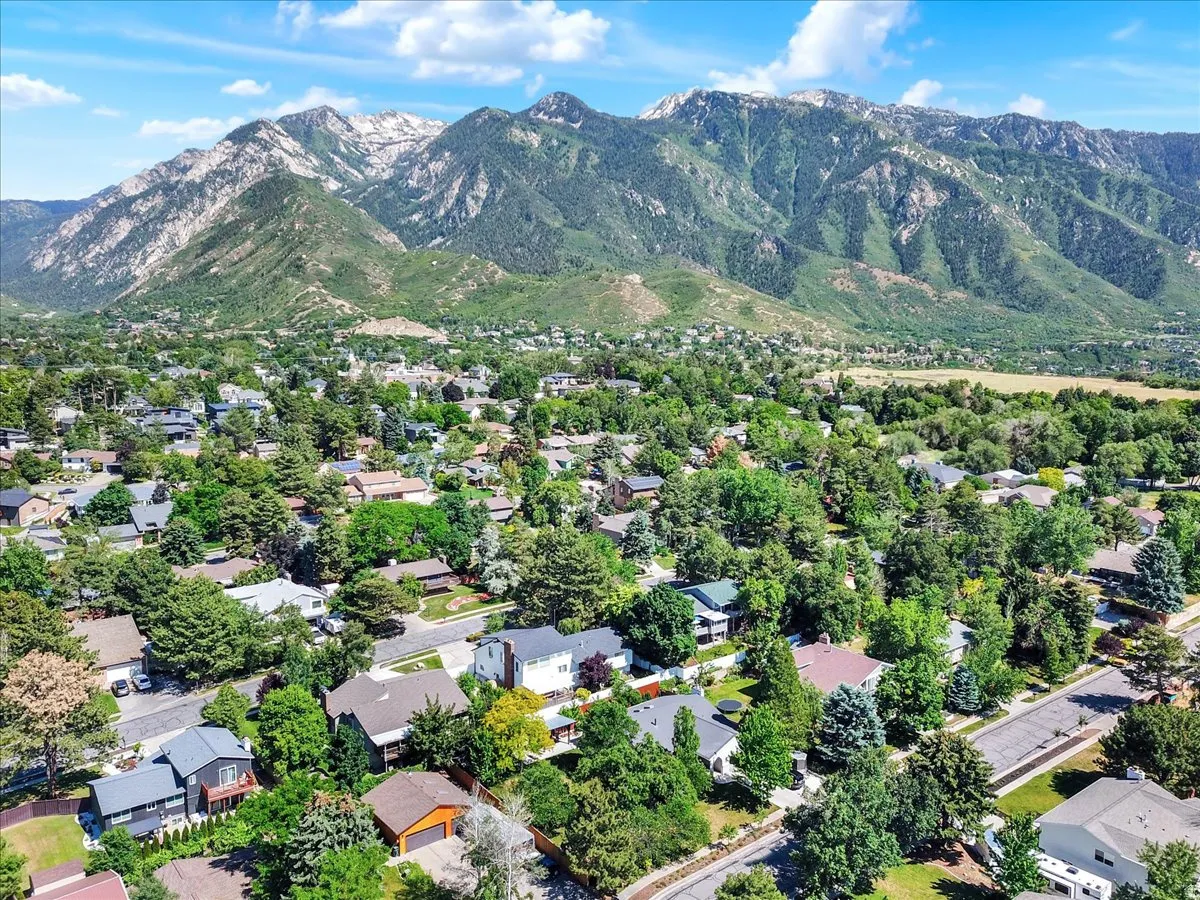 Expansive mountain range backdrop framing a residential area with mature tree cover