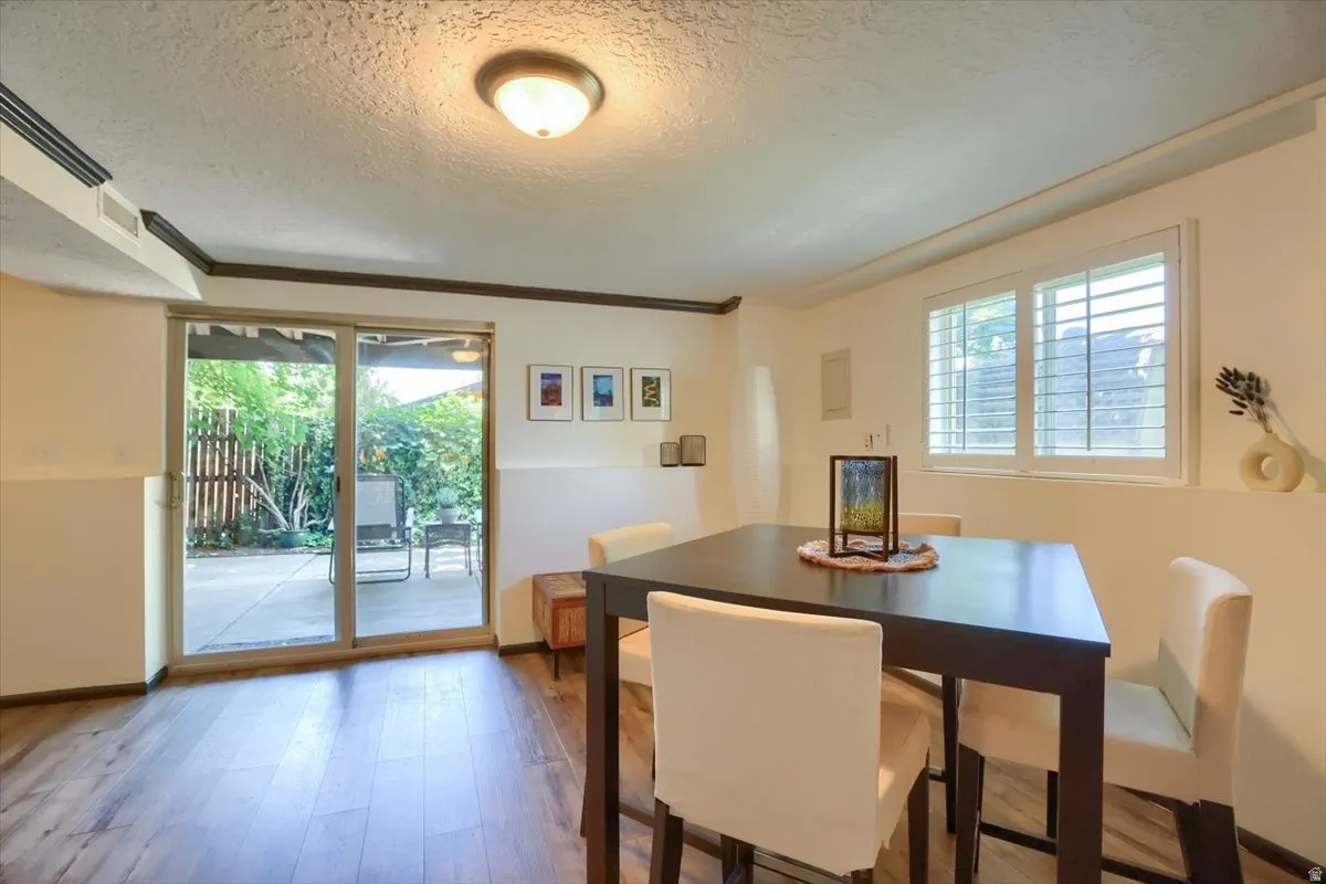 Interior space featuring wood-finish flooring, white walls, and dark crown molding