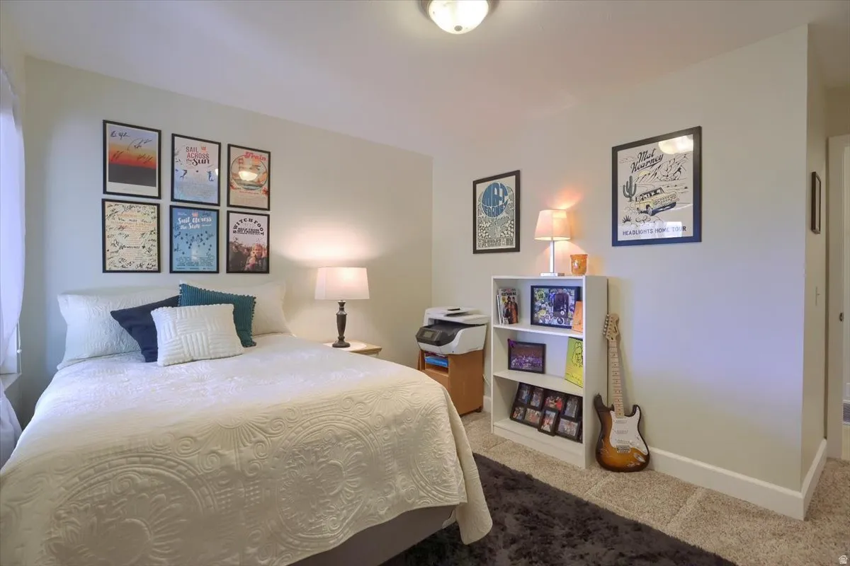 Comfortable room featuring wall-to-wall carpeting, white baseboards, and a neutral wall color