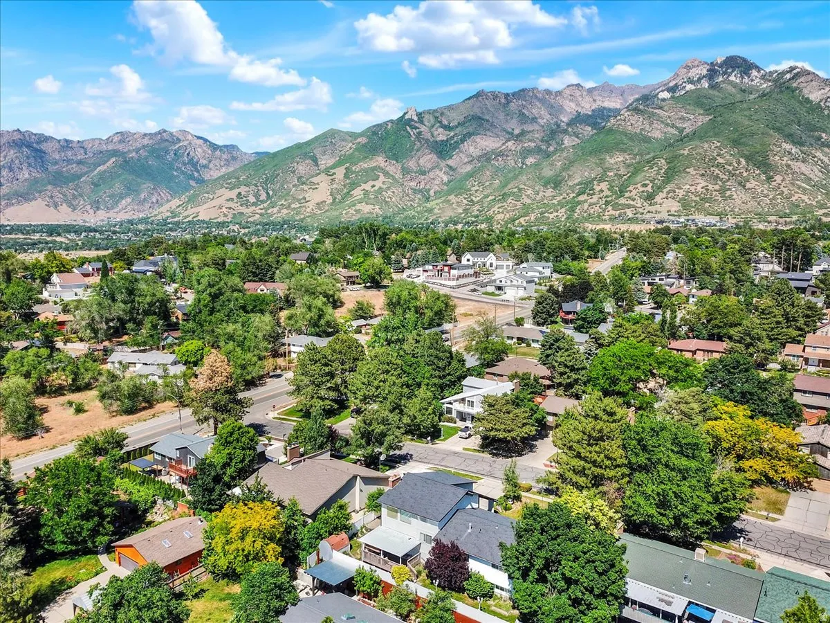 Expansive neighborhood surrounded by lush, mature trees and distant mountain ranges