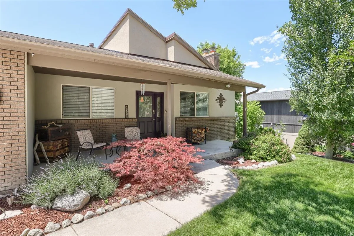 Covered porch entry featuring a double-door, brick siding, and stucco accents