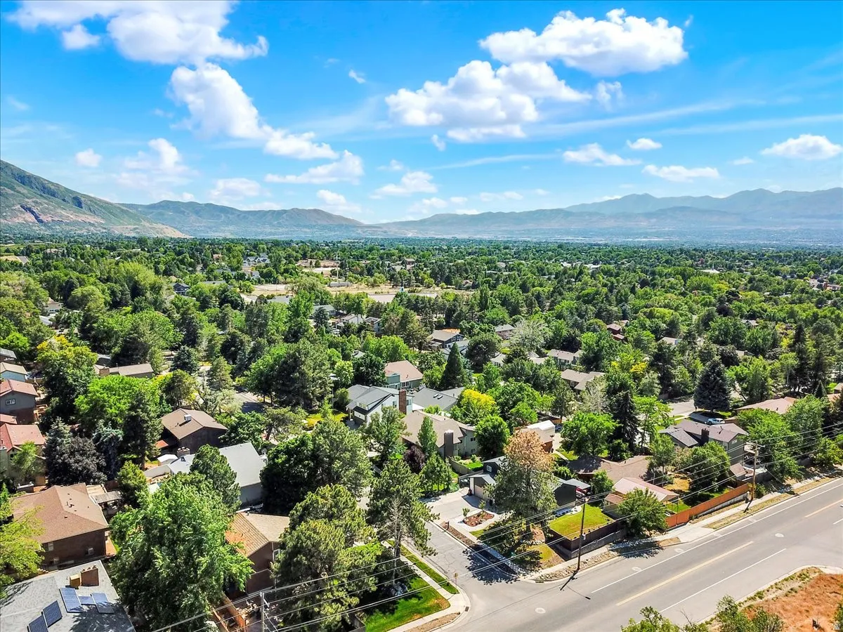Expansive aerial perspective showcasing a residential district with abundant mature trees and distant mountain ranges