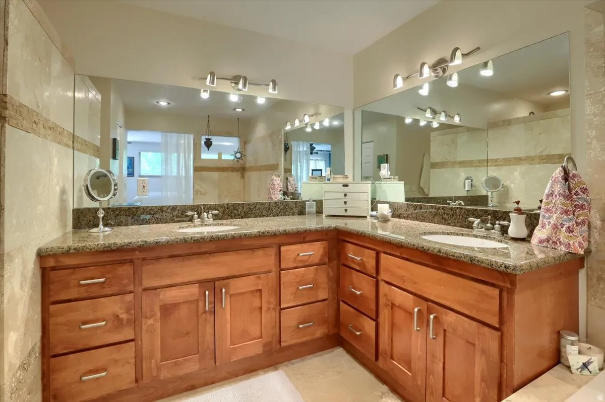 Spacious vanity area featuring twin undermount sinks set within granite countertops