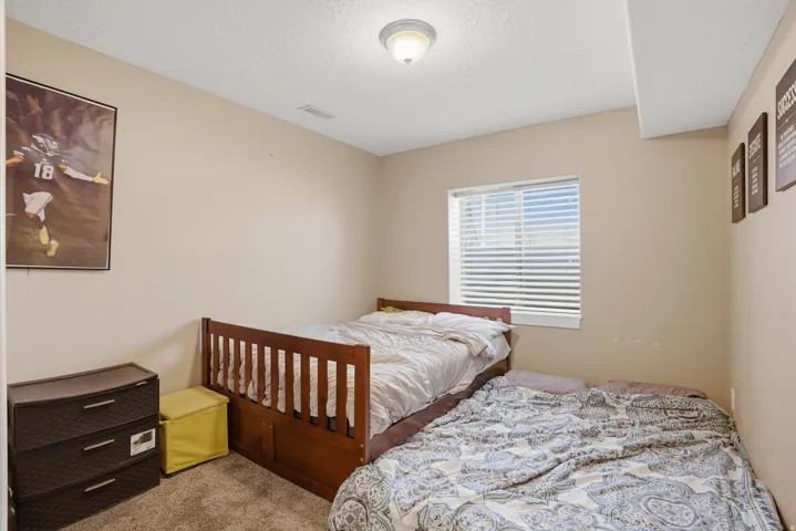 Carpeted room with a single window featuring horizontal blinds