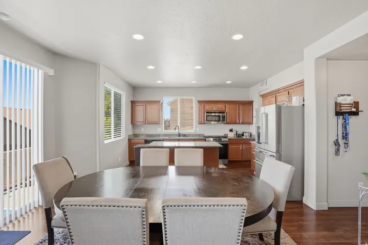Open-concept dining area featuring wood-finish flooring, recessed lighting, and direct access to the kitchen