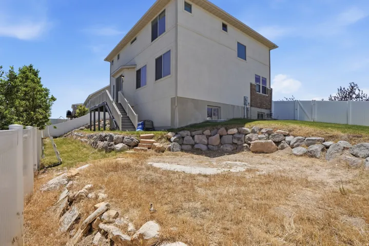 Rear exterior featuring stucco siding and a ground-level patio door