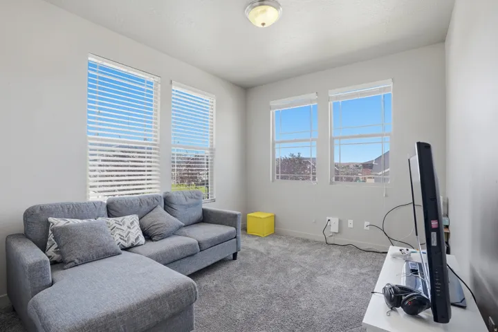 Living area featuring light gray walls and plush gray carpet