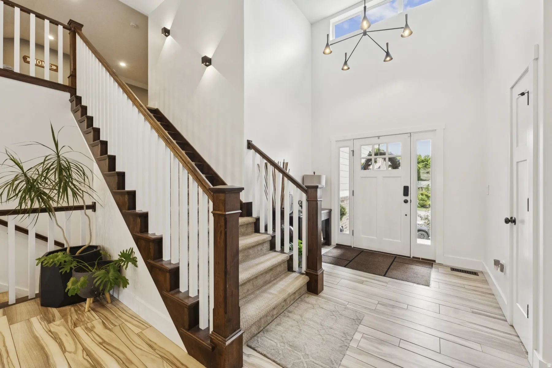 Foyer featuring healthy amount of natural light, light wood-type flooring, and a high ceiling