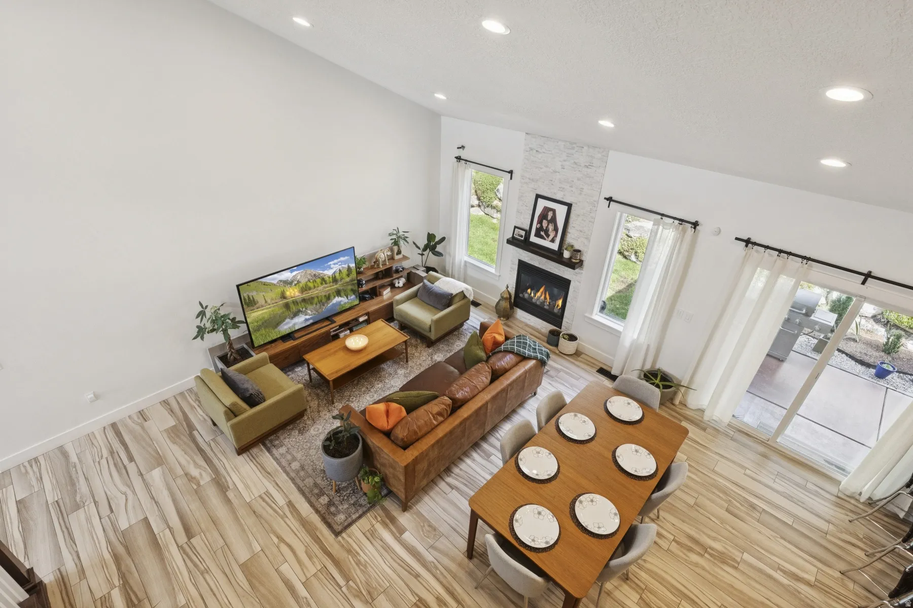 Living room featuring light wood-style flooring, a large fireplace, recessed lighting, and a textured ceiling