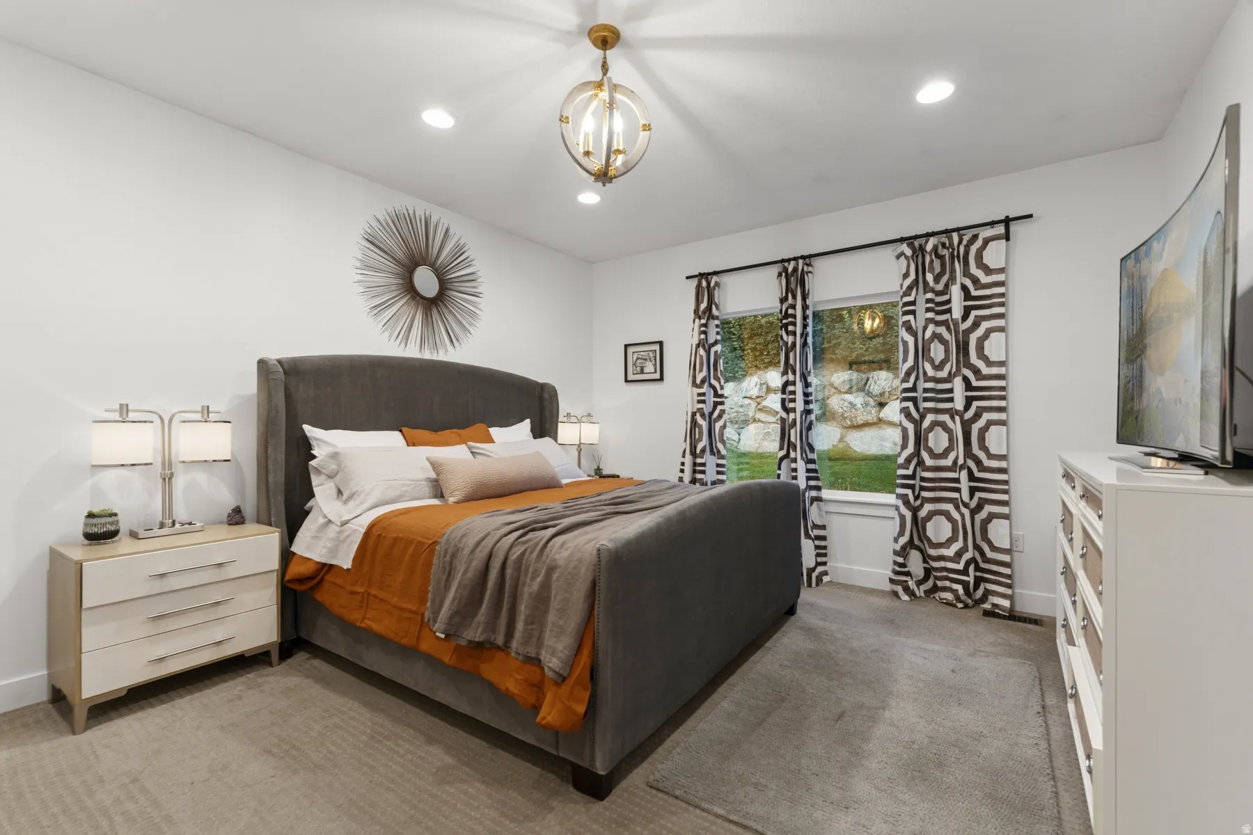 Bedroom featuring light colored carpet and hanging lights