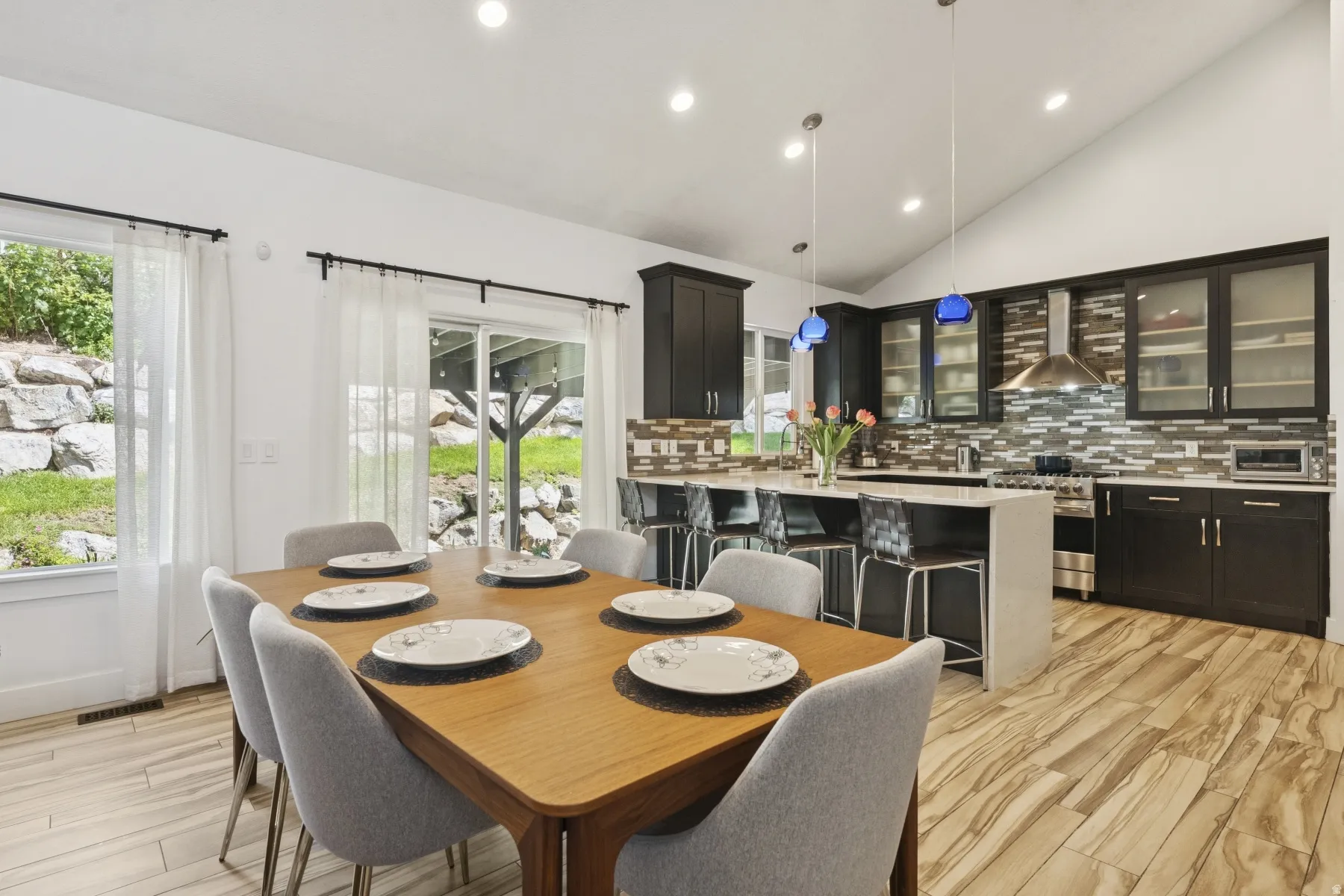Dining area with vaulted ceiling, light wood finished floors, recessed lighting, and plenty of natural light