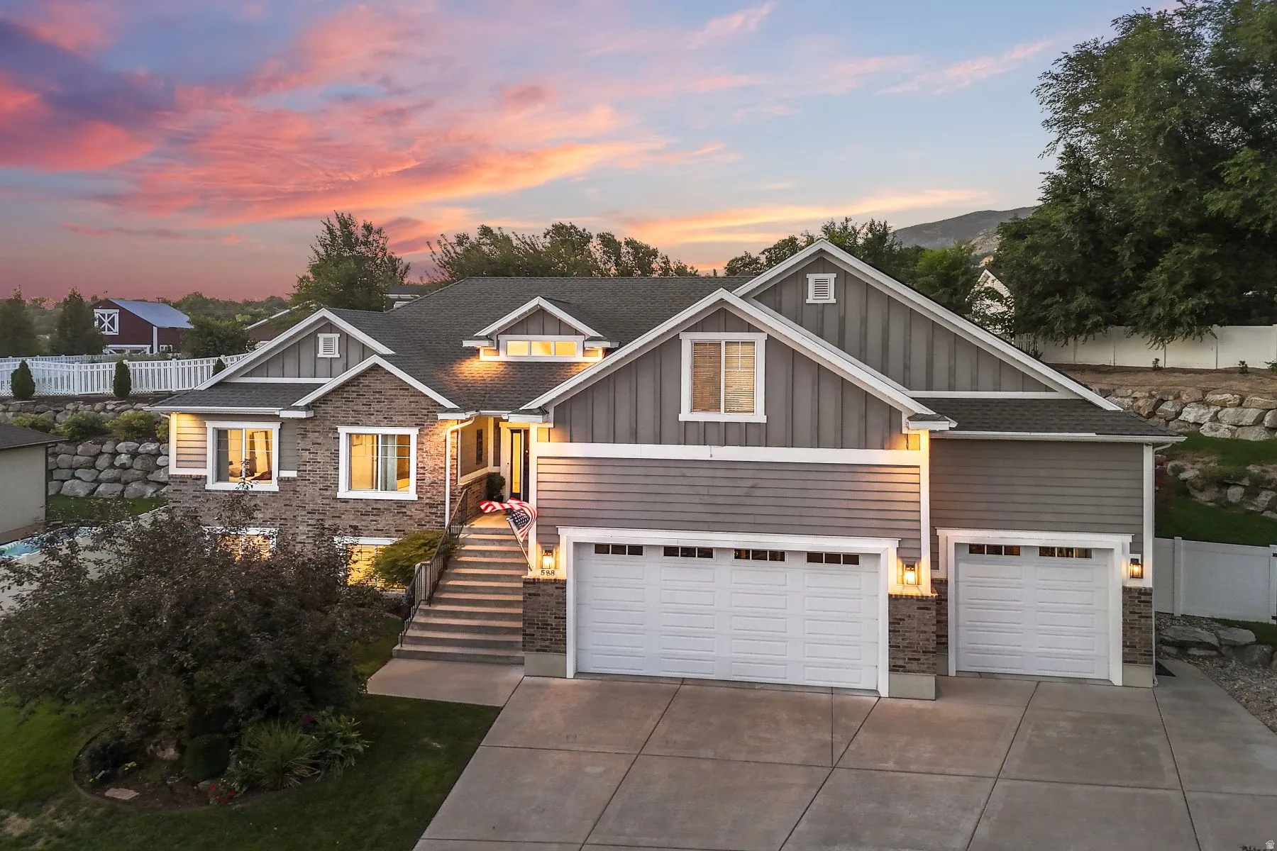 Craftsman house with board and batten siding, driveway, a garage, and roof with shingles