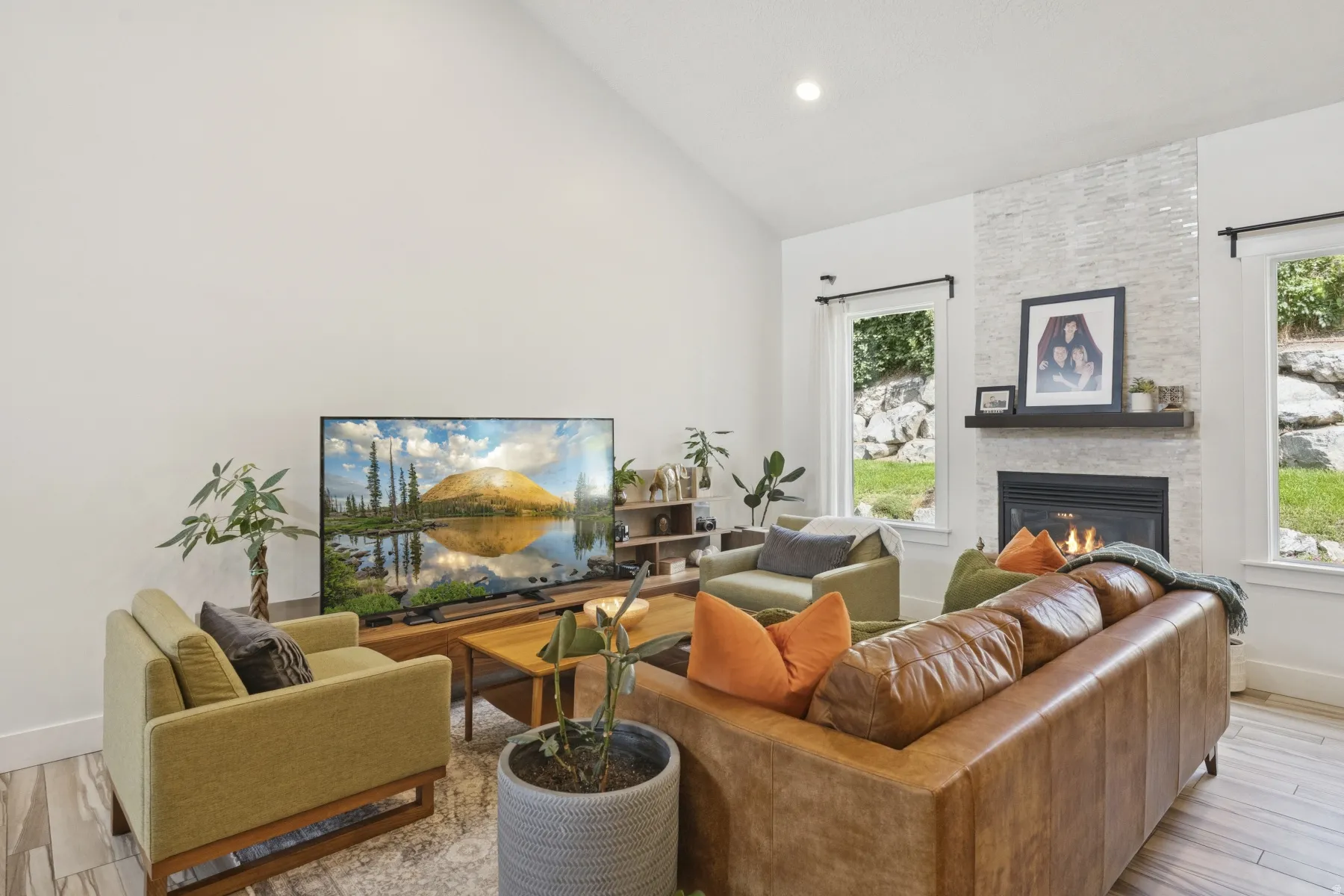 Living area featuring wood finished floors, lofted ceiling, a fireplace, healthy amount of natural light, and recessed lighting