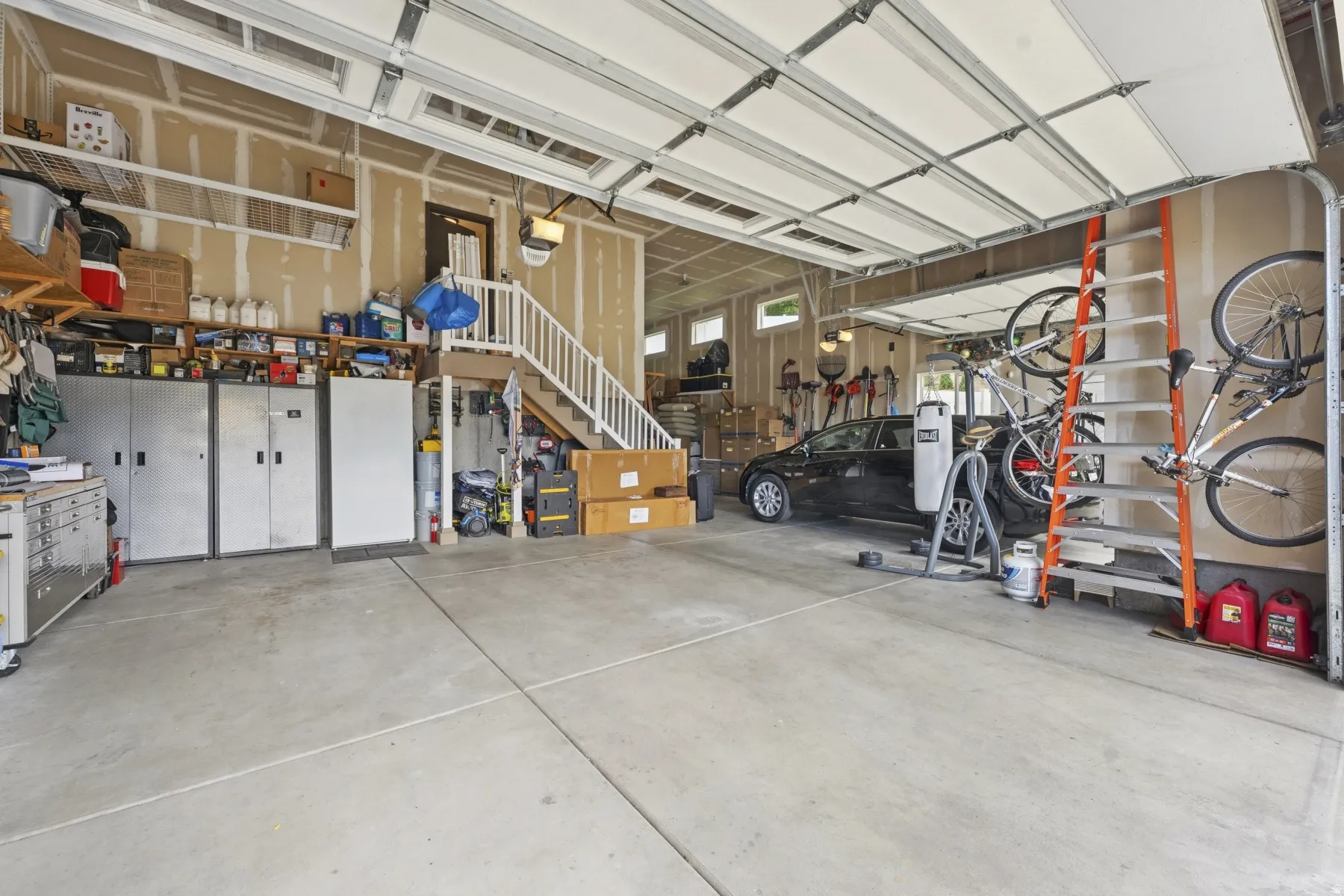 Garage featuring freestanding refrigerator and a workshop area