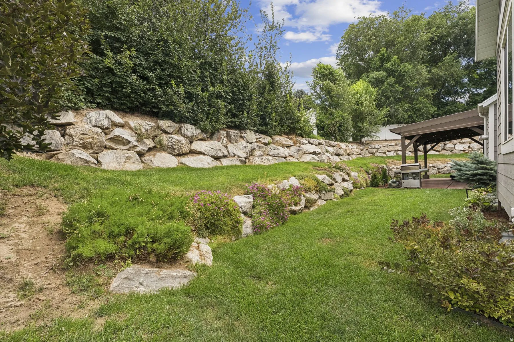 View of green lawn featuring view of scattered trees