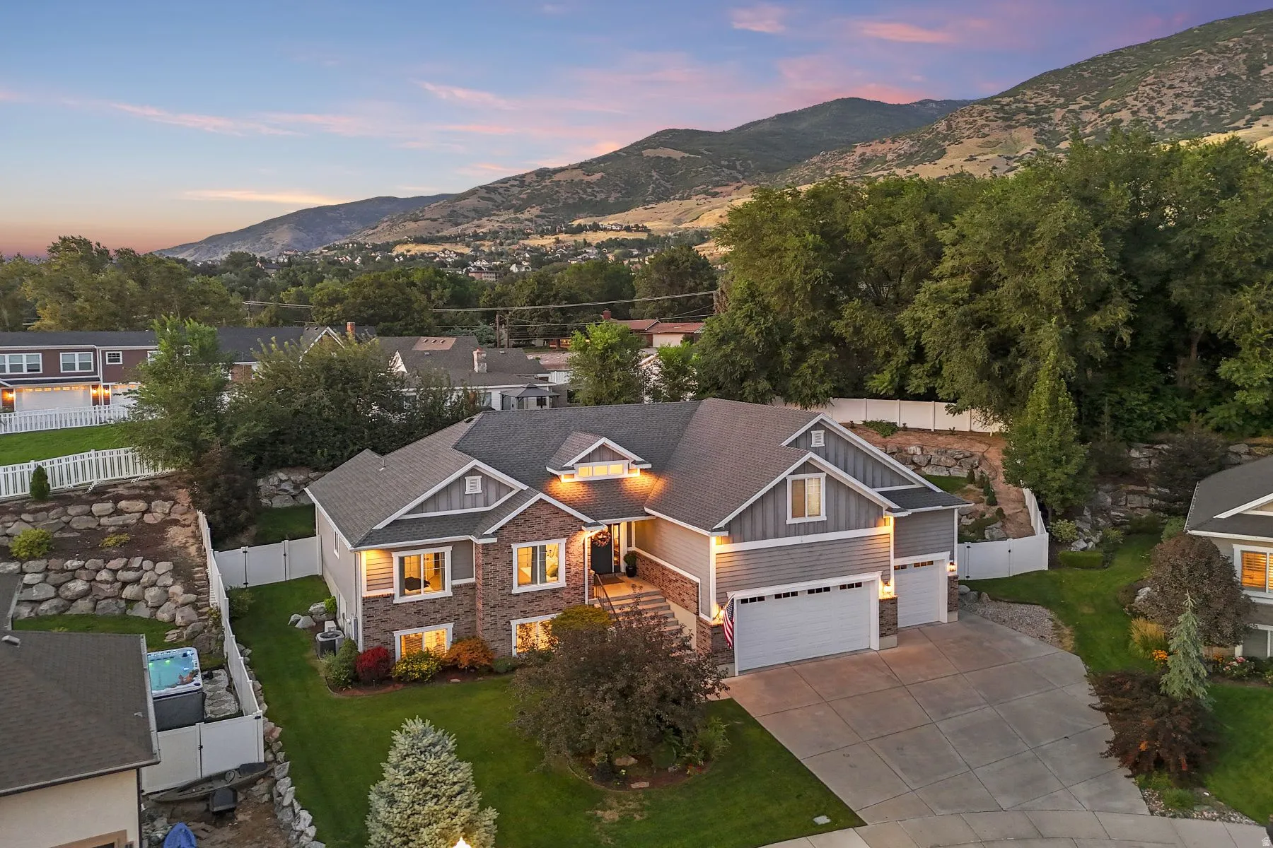 View of front of home featuring board and batten siding, a mountain view, stone siding, a garage, and driveway