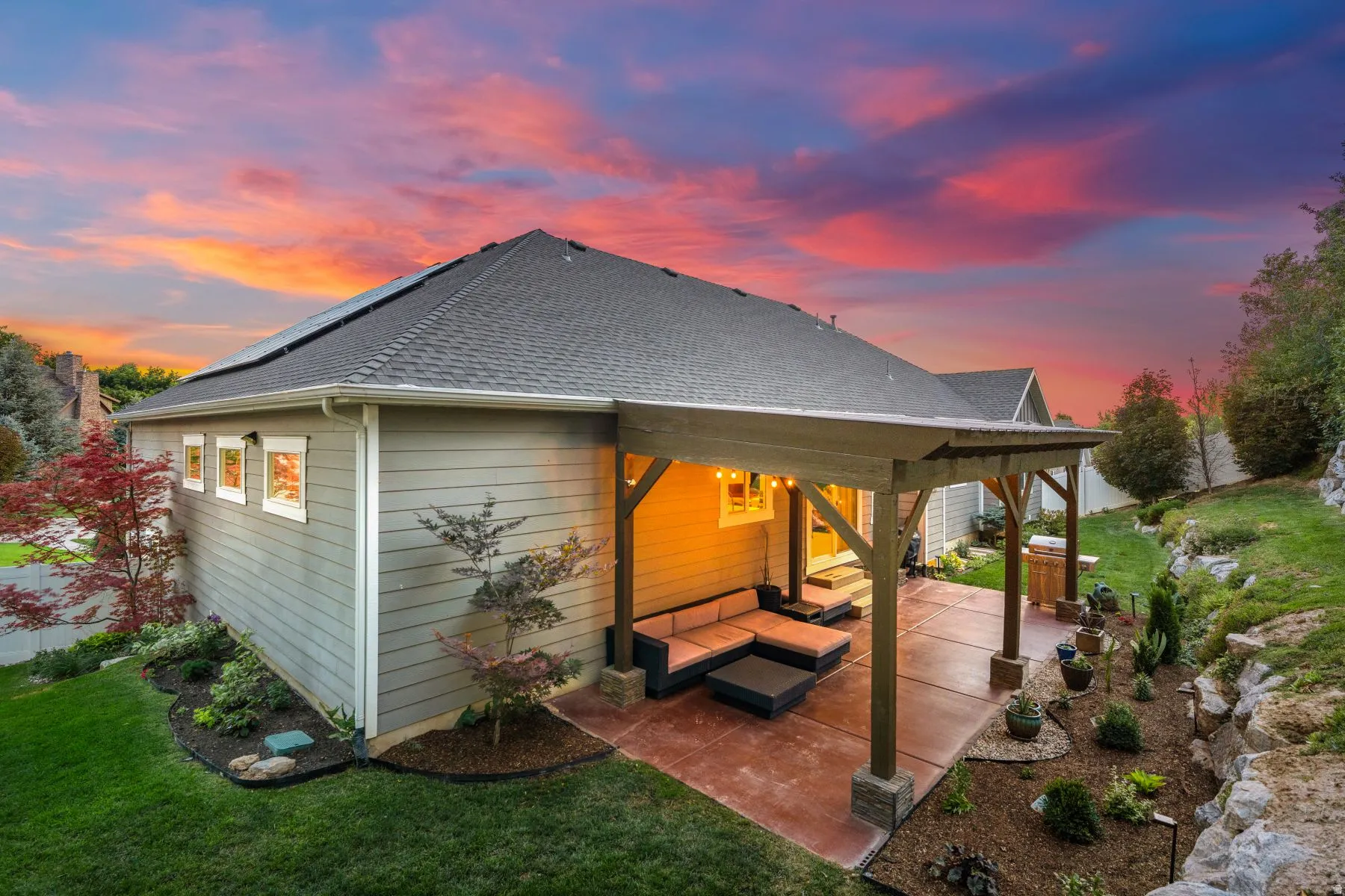 Rear view of house with a shingled roof, a patio, a lawn, and an outdoor hangout area